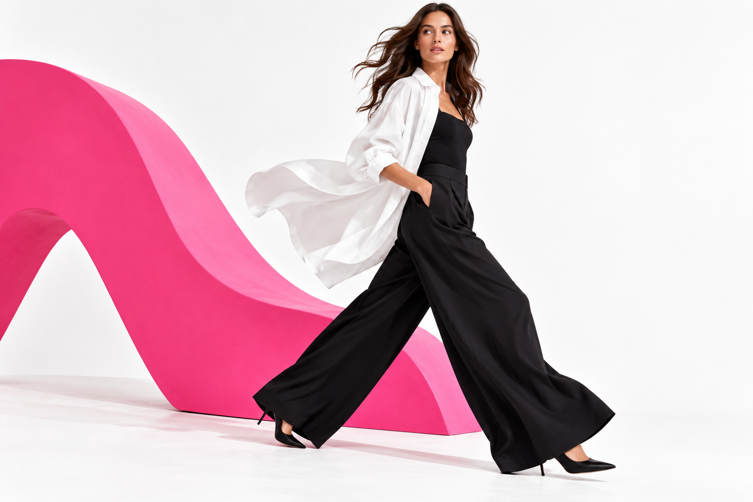 TARLI STUDIO woman in a monochrome look moving through a white and pink studio set
